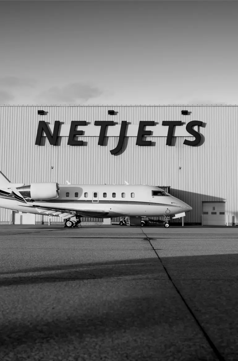 private jet in front of hangar with netjets logo